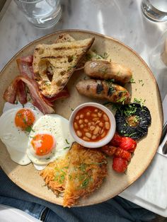 a breakfast plate with eggs, bacon, toast and beans