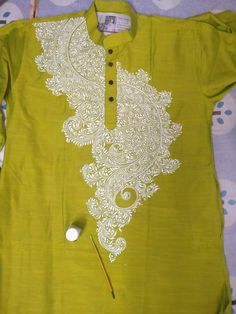 a green shirt with white embroidery on it