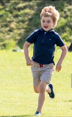 a young boy running across a lush green field