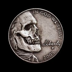 a silver coin with a skull on it