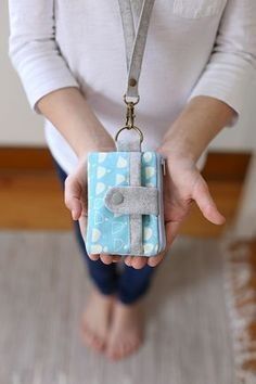 a woman holding a small blue and white case