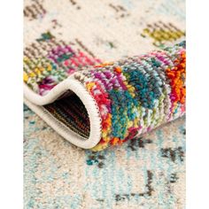 multicolored rug on the floor with white border and colorful pattern, closeup