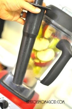 a person is using a blender filled with fruit