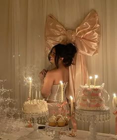 a woman standing in front of a table filled with cakes and cupcakes