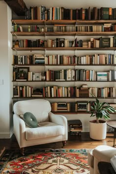 a living room filled with furniture and lots of books on the shelves in front of it