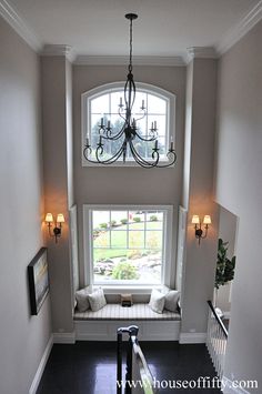 an entry way with a window seat and chandelier