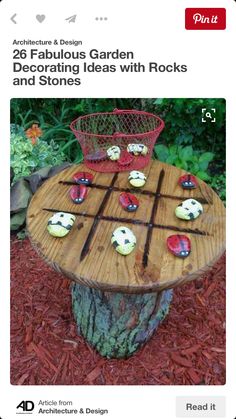 an outdoor table made out of wood with rocks on it and a basket full of cupcakes