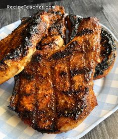 two pieces of grilled meat on a white and blue checkered plate with text overlay