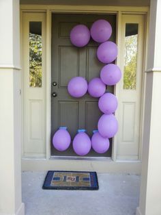 purple balloons are hanging on the front door