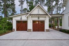 a white house with two brown garage doors