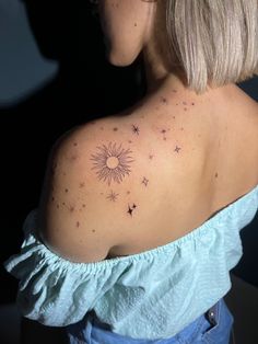 the back of a woman's shoulder with small stars on her left arm and sun in the middle