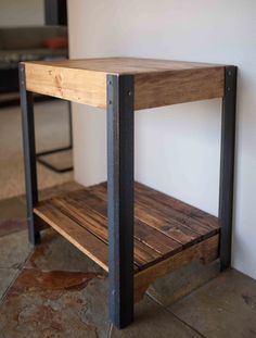 a wooden table with metal legs and a shelf on the wall in front of it