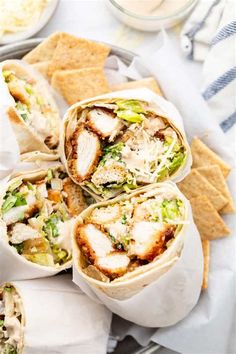 several burritos with chicken, lettuce and cheese in them on a plate