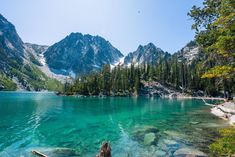 a lake surrounded by mountains with clear blue water