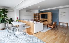 a living room filled with furniture and a flat screen tv on top of a wooden shelf