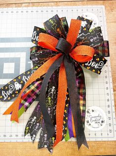 a close up of a bow on top of a cutting board with scissors and tape