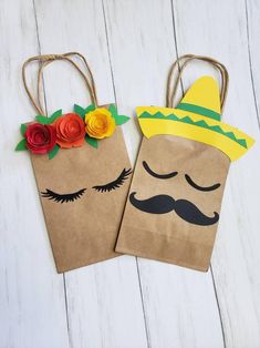 two brown paper bags decorated with flowers and fake mustaches on white wood flooring