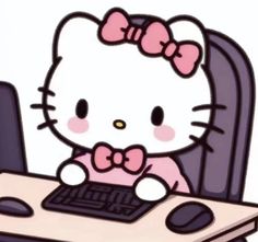 a hello kitty sitting at a desk with a keyboard and mouse in front of her