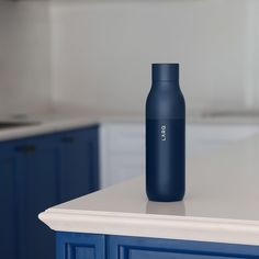 a blue bottle sitting on top of a white counter