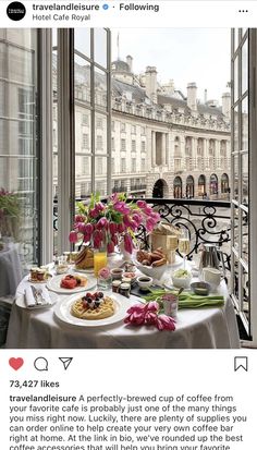 a table with food and drinks on it in front of a window overlooking the city