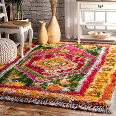 a colorful area rug is on the floor in front of a white chair and vases