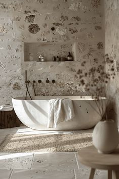 a white bath tub sitting in a bathroom next to a wall with flowers on it