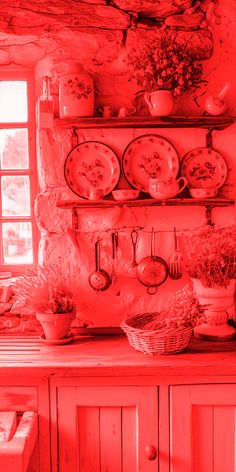 an old fashioned kitchen with red light coming through the window and dishes on the shelf