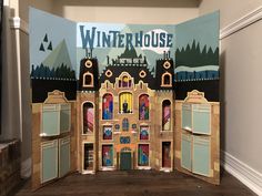 a cardboard cutout of a winter house in front of a wall with the words winterhouse on it