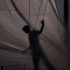 a man standing next to a white sail boat