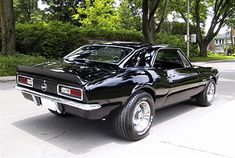 a black muscle car parked on the street