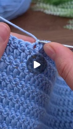 someone is crocheting the stitchs on their blue sweater