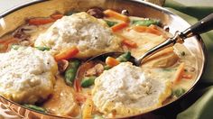 a pot filled with dumplings and vegetables on top of a table