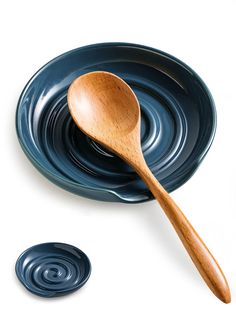 a wooden spoon sitting on top of a blue plate next to an empty bowl and saucer