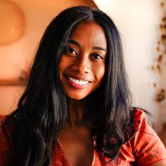 a woman with long black hair smiling at the camera