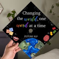 someone is holding up a graduation cap that says changing the world, one word at a time