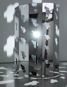 three mirrored cubes in the middle of a room with light coming through them and shadows on the floor