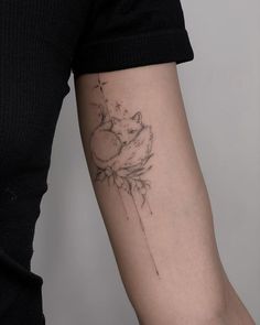 a woman's arm with a tattoo on it that has a cat sleeping on top of a star