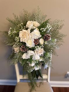 a bouquet of white flowers sitting on top of a wooden chair next to a wall