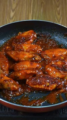 chicken wings are being cooked in a skillet