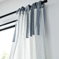 the curtains are hanging on the rod in front of the window with blue and white checkered drapes