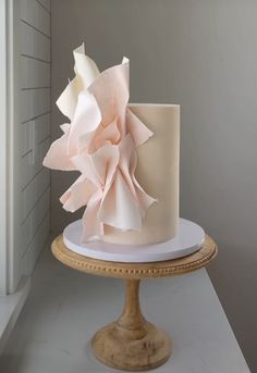 a white and pink cake sitting on top of a table