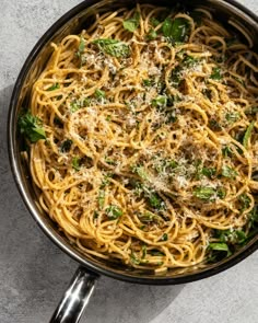 pasta with spinach and parmesan cheese in a skillet on a table