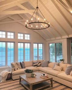 a living room filled with furniture and large windows