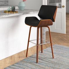 a bar stool sitting in front of a counter top next to a vase with flowers on it