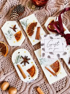 orange slices and cinnamons are arranged on small coasters with ribbons, pine cones, and an ornament