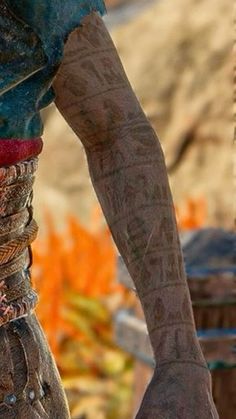 a close up of a person's arm with bracelets and rings on it