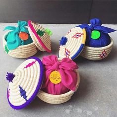 three baskets with hats on them sitting on the ground