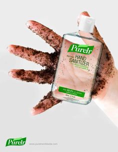 hand sanitizer is being held up by someone's hands with dirt on them