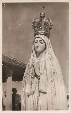 an old black and white photo of a statue of the virgin mary wearing a crown