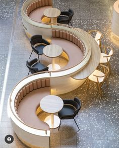 an overhead view of two circular tables and chairs in a room with concrete flooring